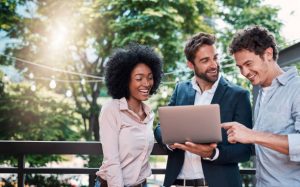 Shot of a group of businesspeople working together on a laptop outdoors