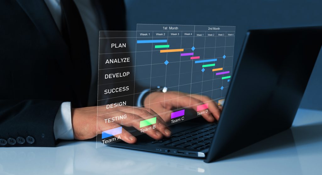 Project manager working on laptop and updating tasks and milestones progress planning with Gantt chart scheduling interface for company on virtual screen.Business Data Management System